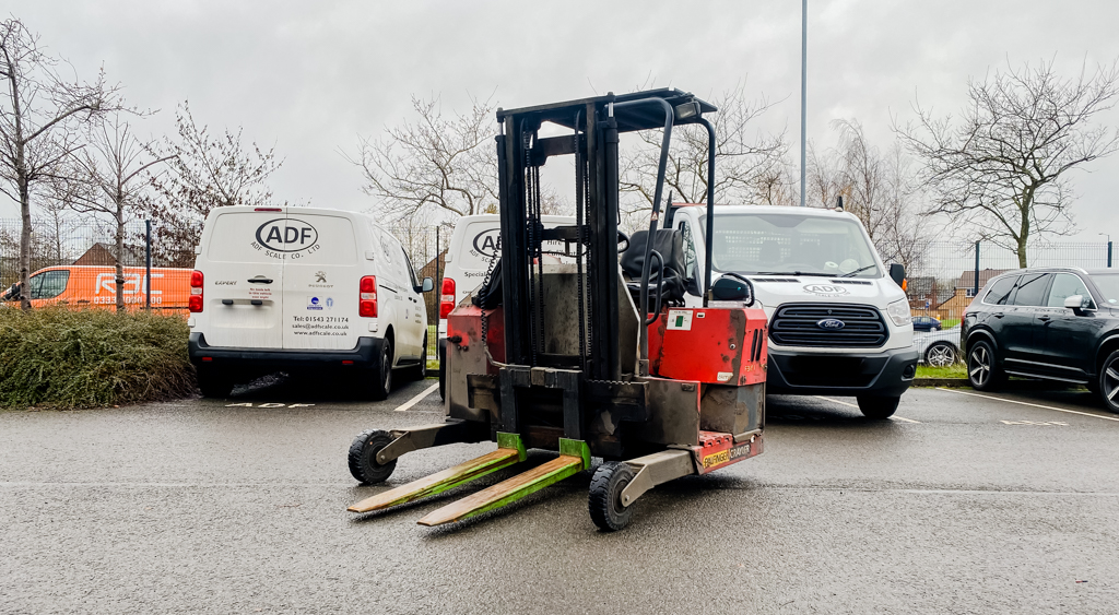 A forklift truck weighing system in a car park, showing the pallet prongs in front