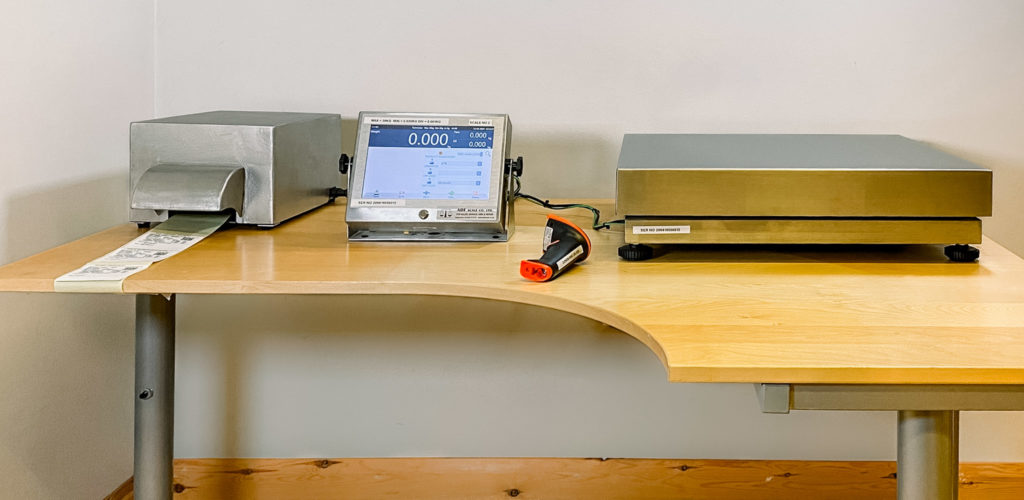 A desk with a bespoke weighing system on top including a printer, digital display and platform scale