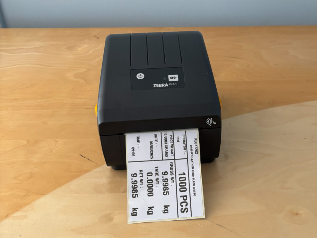 Image of a small black label printer showing gross and net weight