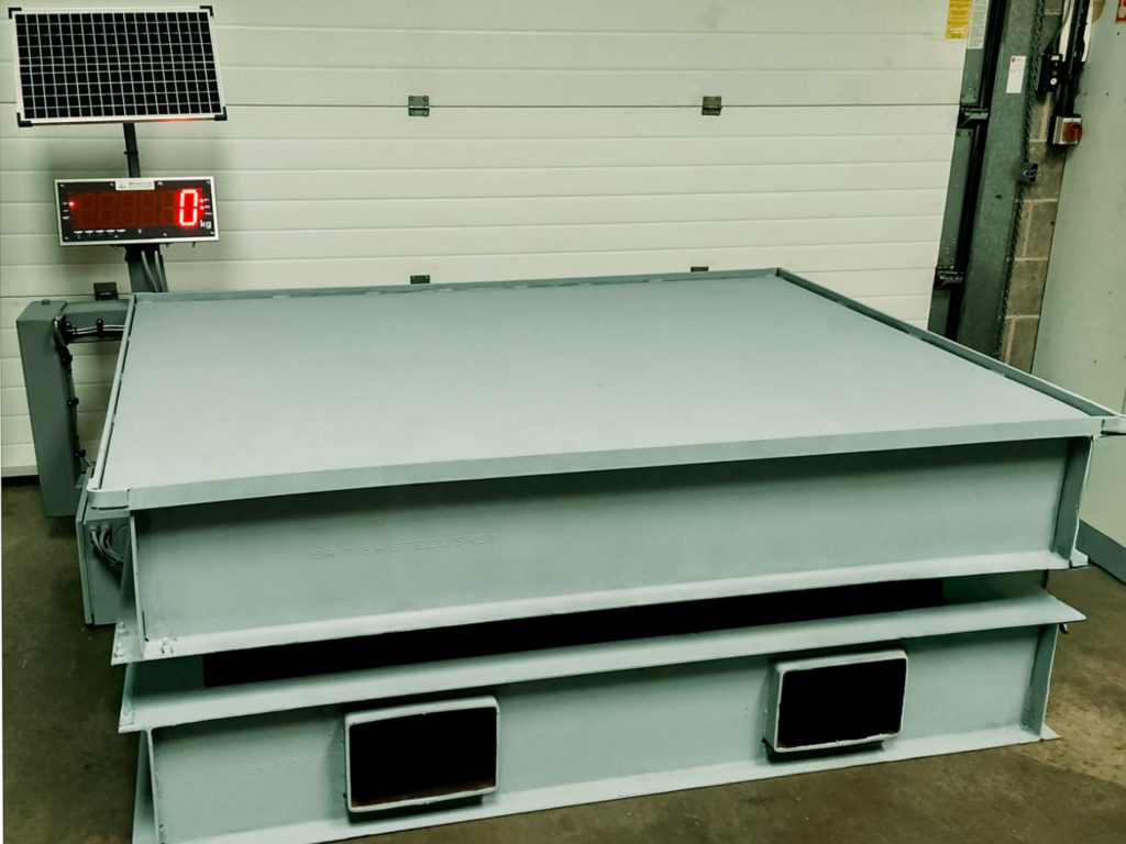 portable weighing platform on raised frame in quarry with large digital display and solar panel