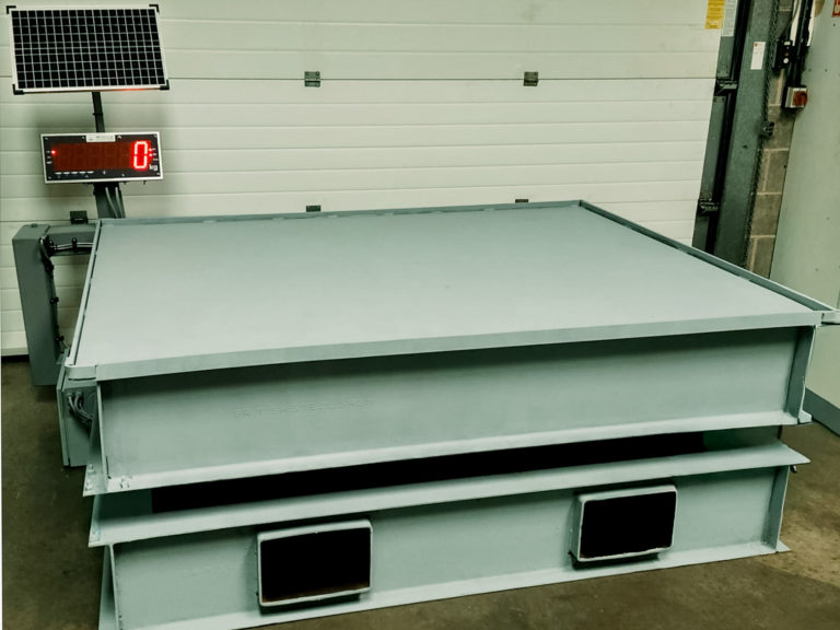 portable weighing platform on raised frame in quarry with large digital display and solar panel