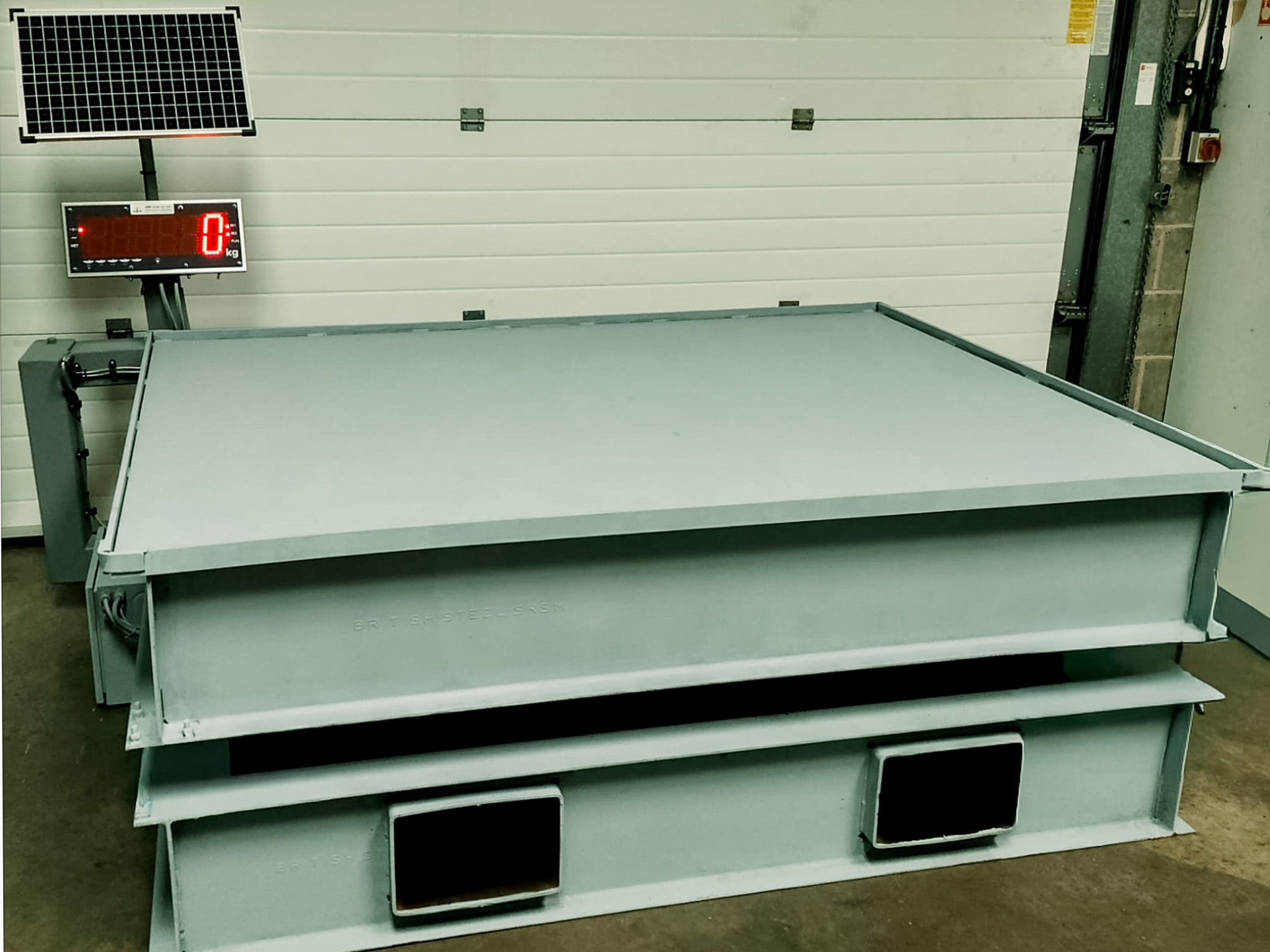 portable weighing platform on raised frame in quarry with large digital display and solar panel