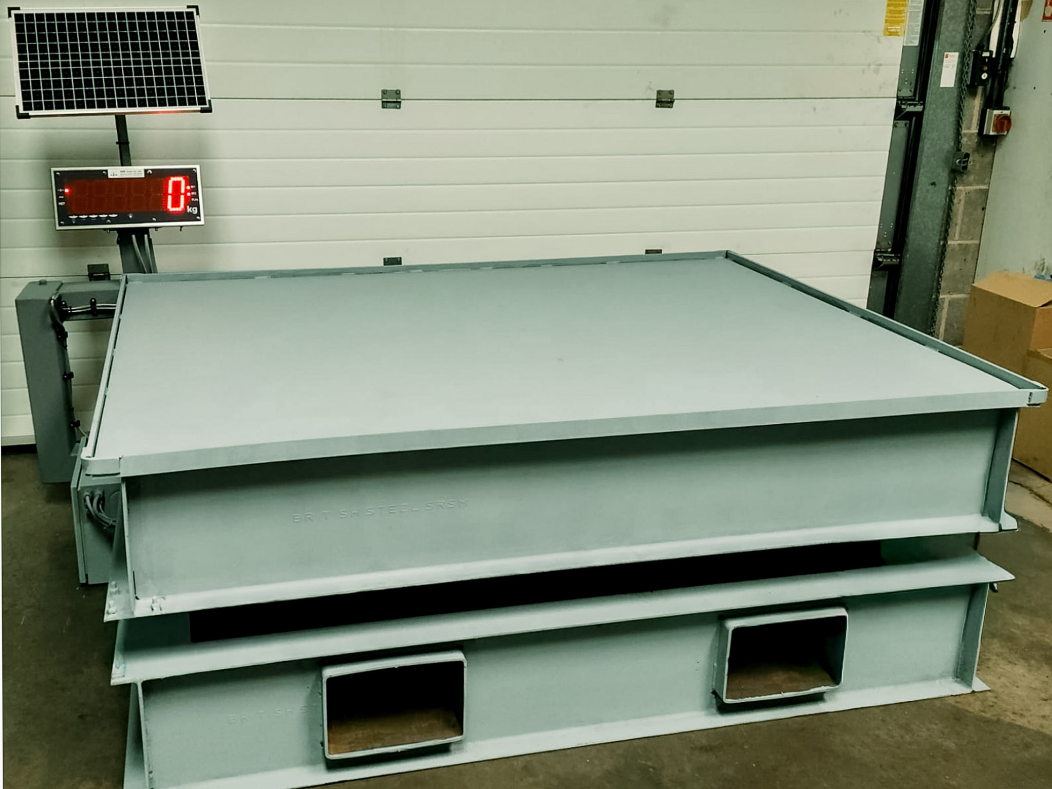 portable weighing platform on raised frame in quarry with large digital display and solar panel